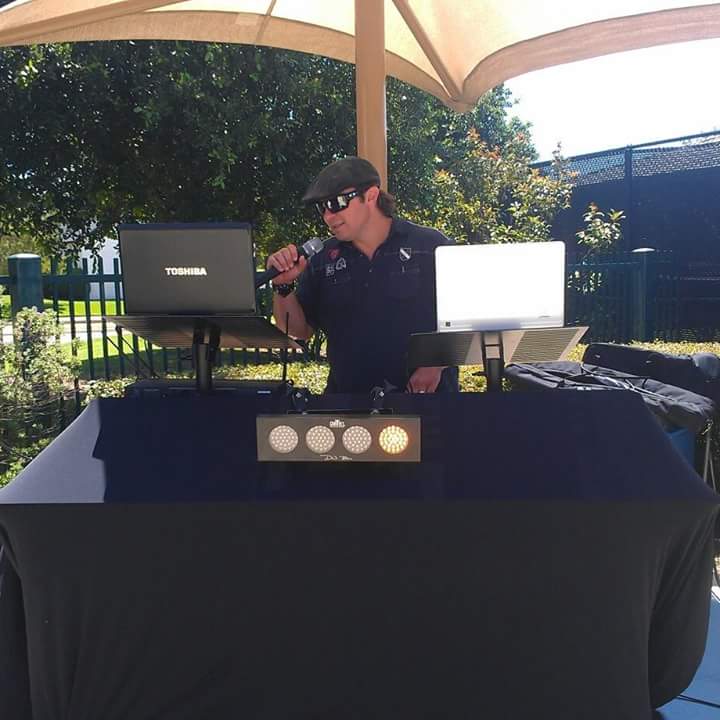 A man singing into a microphone in front of a toshiba laptop