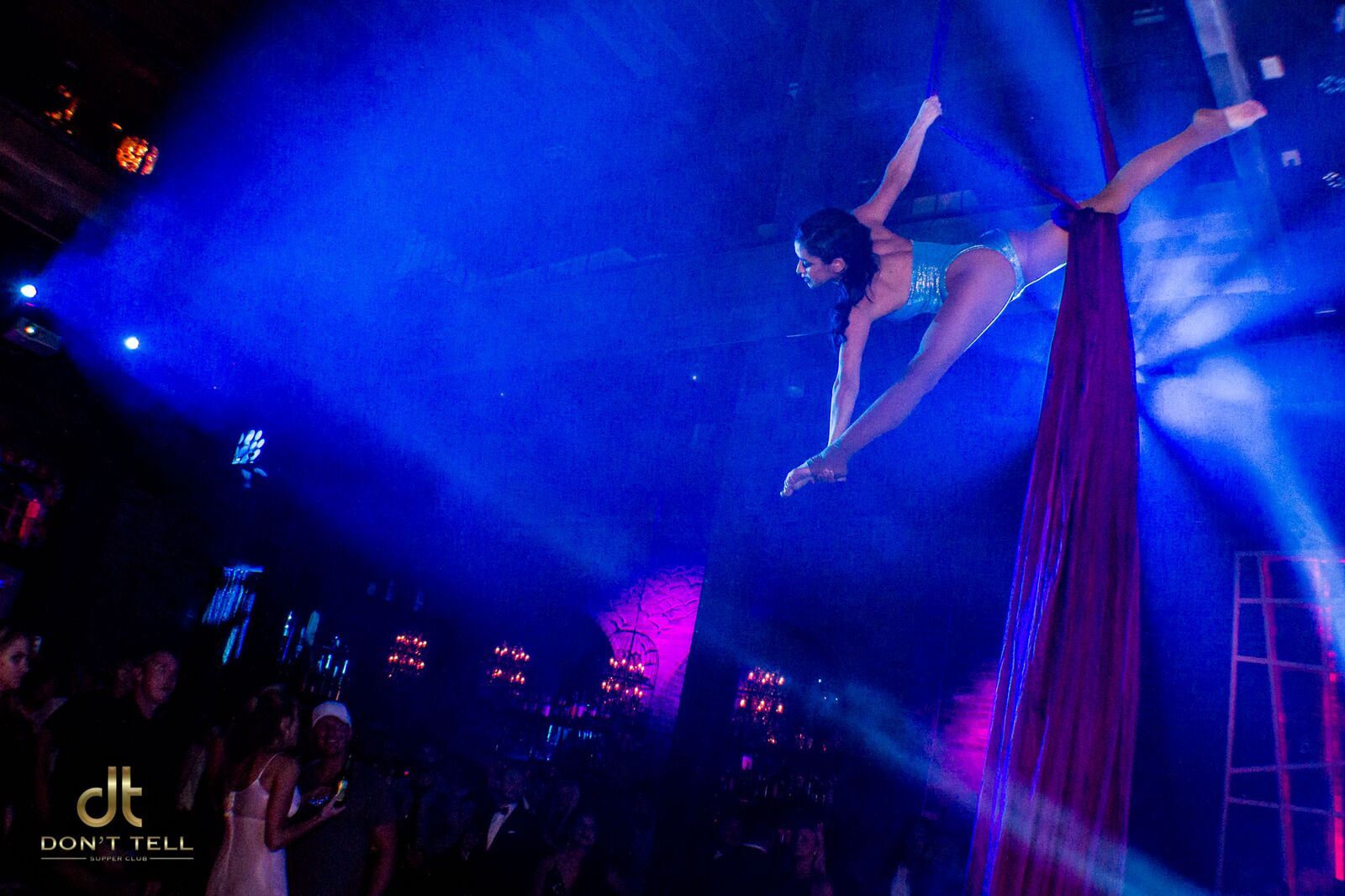 A woman is flying through the air on a red cloth.