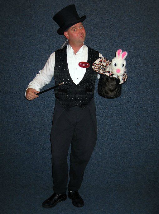 A man in a top hat is holding a rabbit in a hat