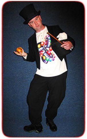 A man in a top hat is holding an apple and a magic wand