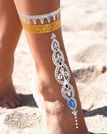 A woman 's leg with a metallic tattoo on it