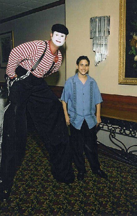 A man standing next to a mime on stilts