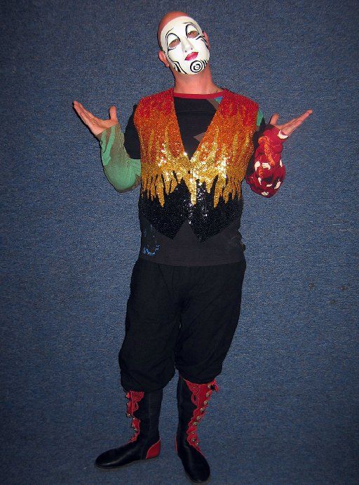 A man in a clown costume has his arms outstretched