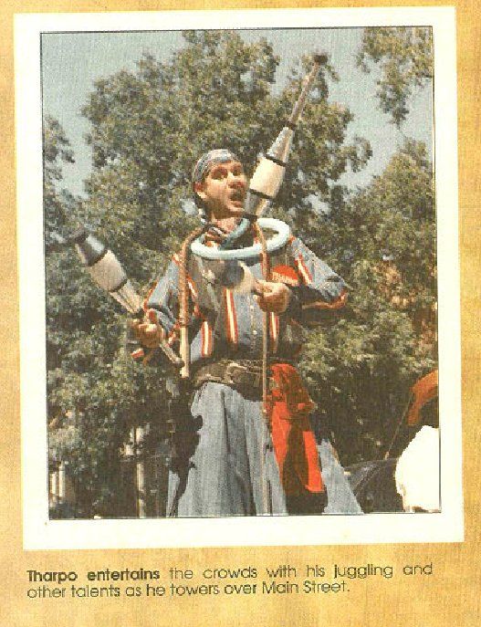 A picture of a man juggling with a snake around his neck