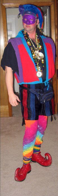 A man in a colorful costume is standing in front of a door.