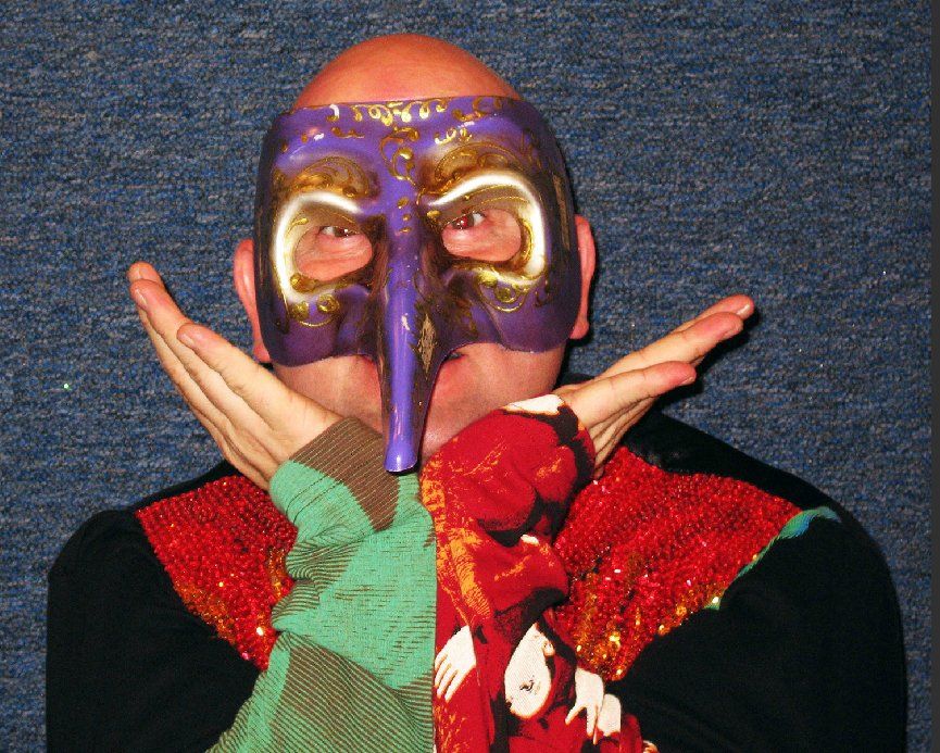 A bald man wearing a purple and gold mask
