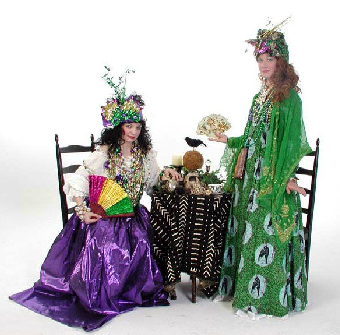 A woman in a purple dress sits next to a woman in a green dress