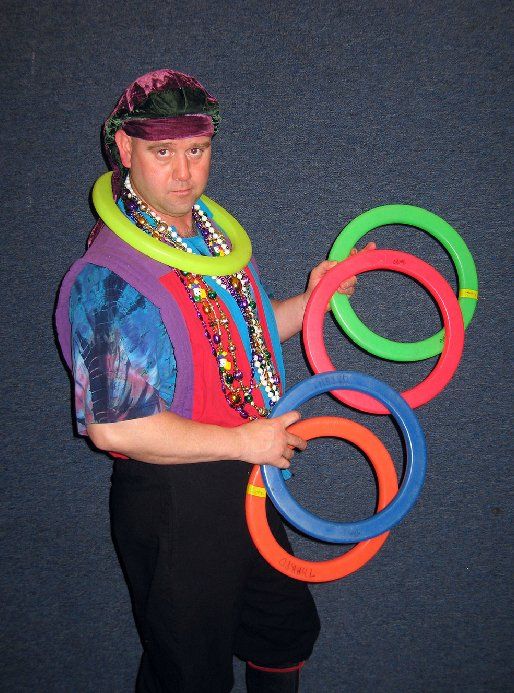 A man is holding a bunch of colorful rings around his neck
