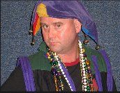 A man is wearing a jester hat and beads.