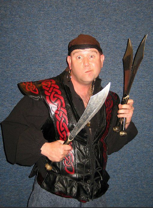A man in a pirate costume is holding two swords
