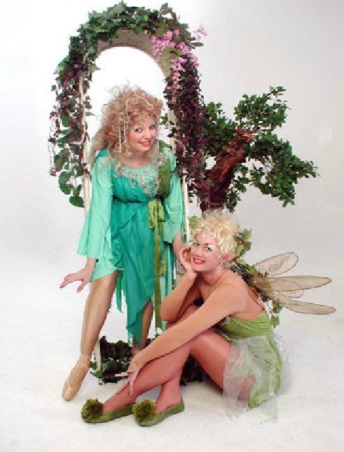 Two women dressed as fairies are posing for a picture