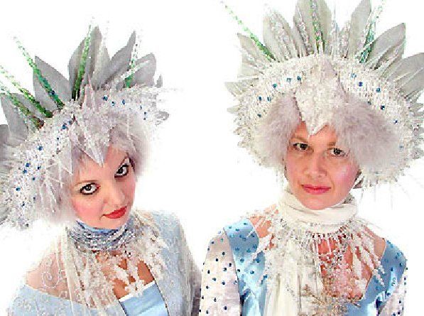 Two women dressed as snow queens are standing next to each other.