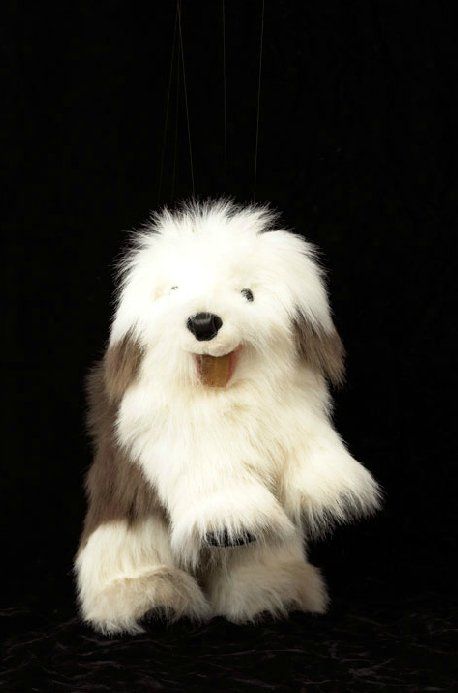 A stuffed dog is sitting on a black background.