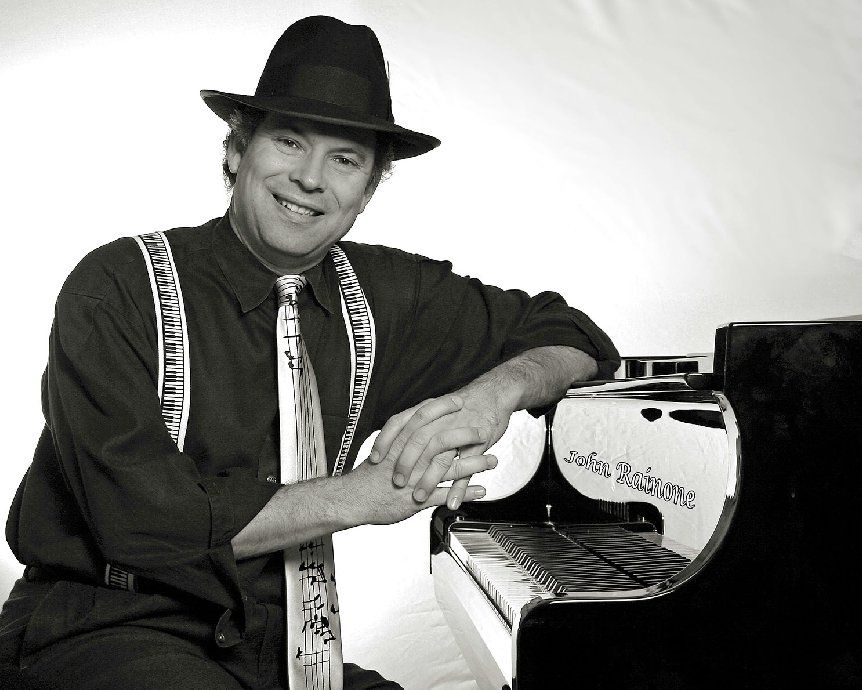 A man wearing a hat and tie is leaning against a piano