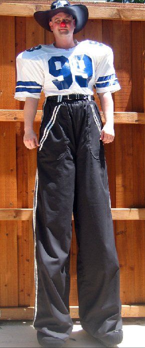 A man on stilts wearing a number 99 jersey