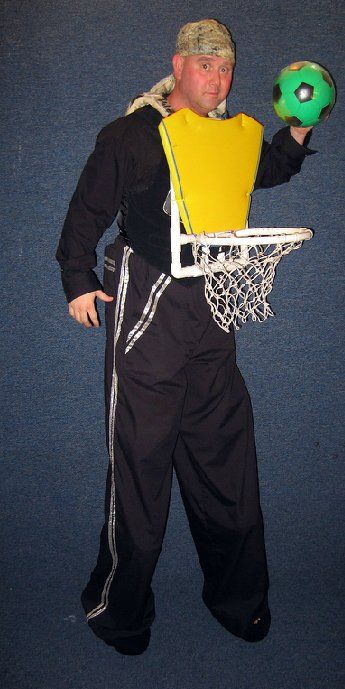 A man is holding a soccer ball and a basketball hoop