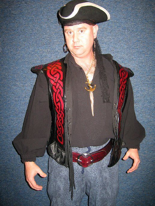 A man in a pirate costume is wearing a black hat