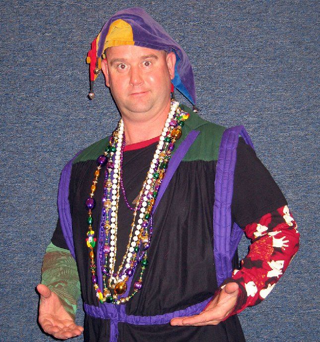 A man wearing a jester hat and a necklace of beads