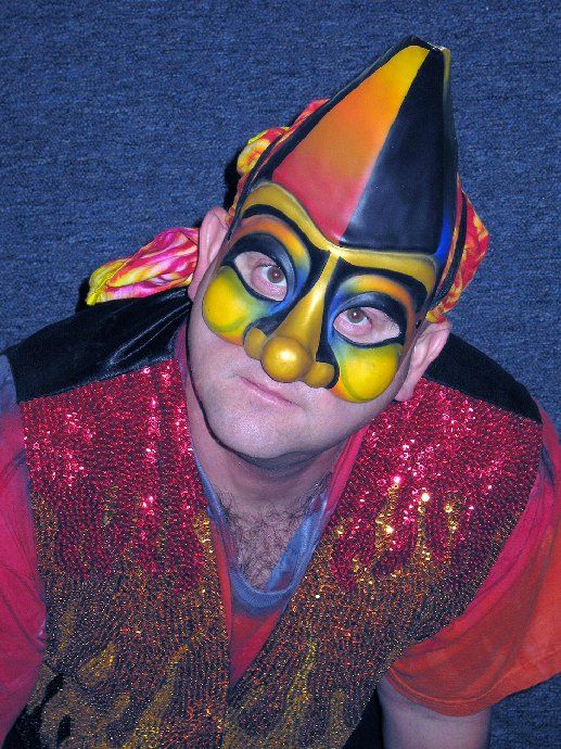 A man wearing a clown mask and a red vest