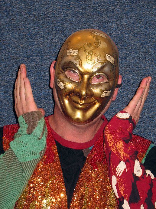 A man wearing a gold mask is making a funny face