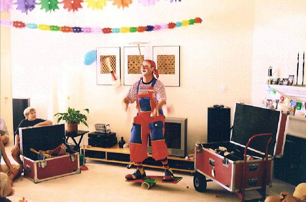 A man dressed as a clown is standing in a living room