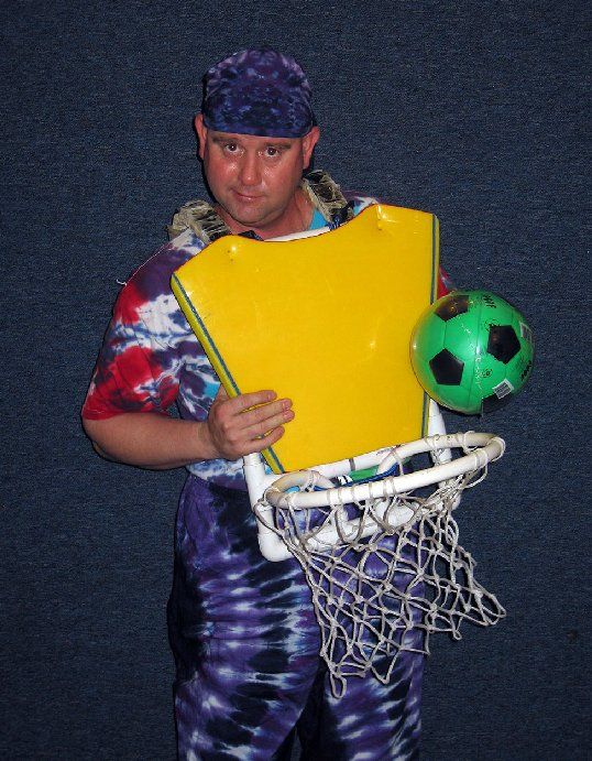 A man is holding a basketball hoop and a soccer ball