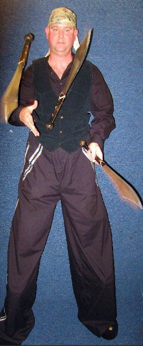 A man in a pirate costume is holding two swords
