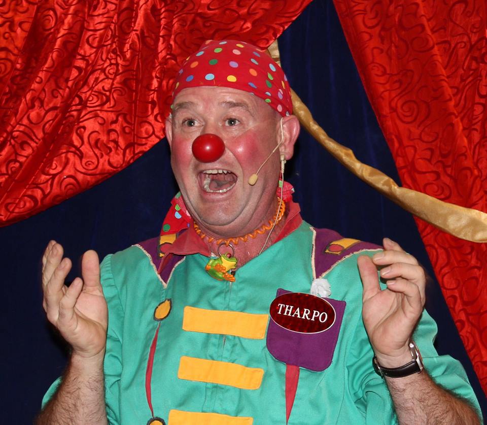 A man in a clown costume has a tag that says tharpo