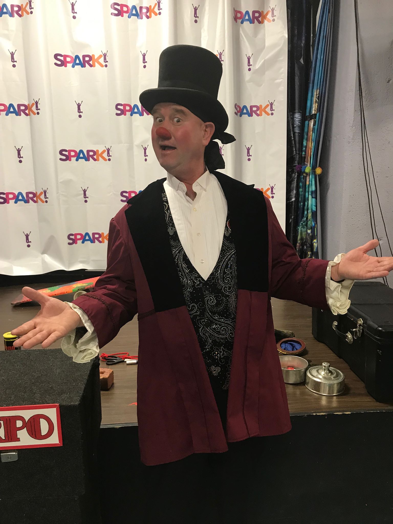 A man dressed as a clown is standing in front of a sign that says no.