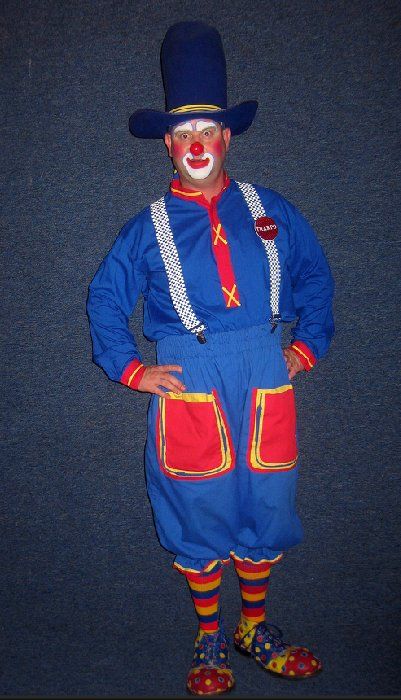 A clown is wearing a blue top hat and suspenders