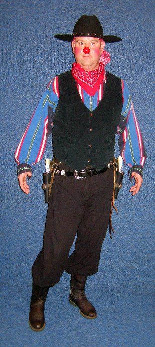 A man in a cowboy costume with a red nose