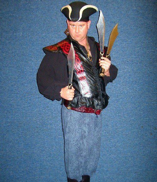 A man in a pirate costume is holding two swords