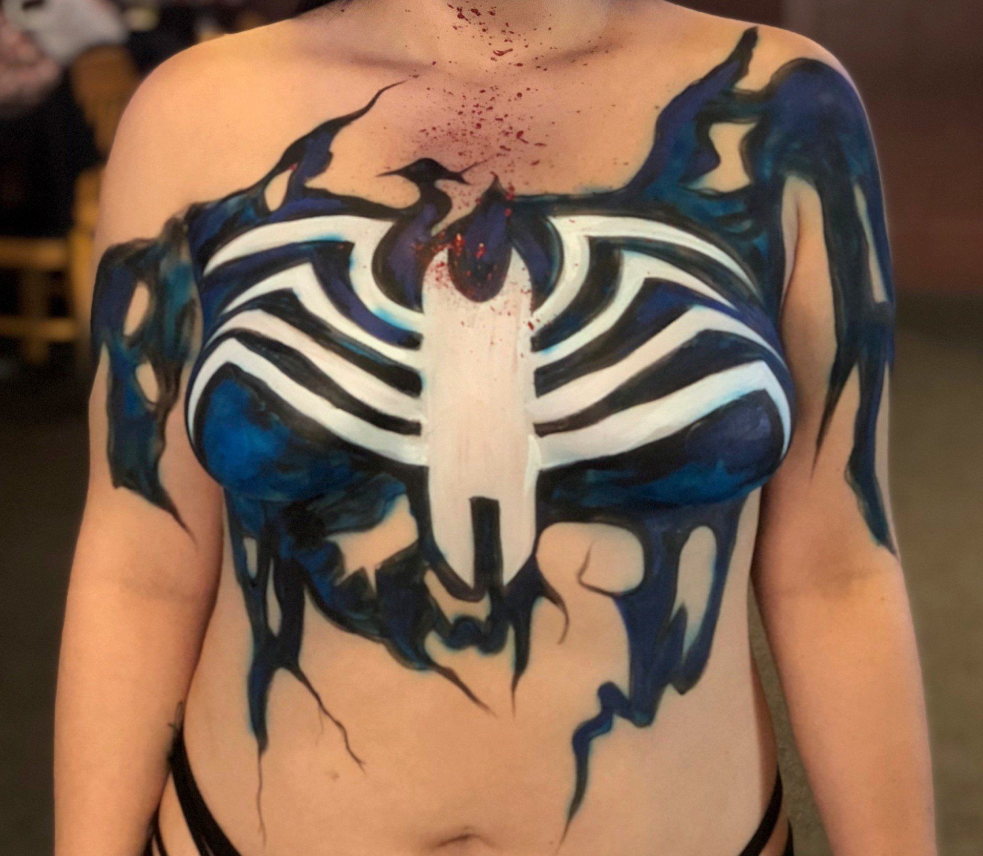 A woman has her body painted like venom