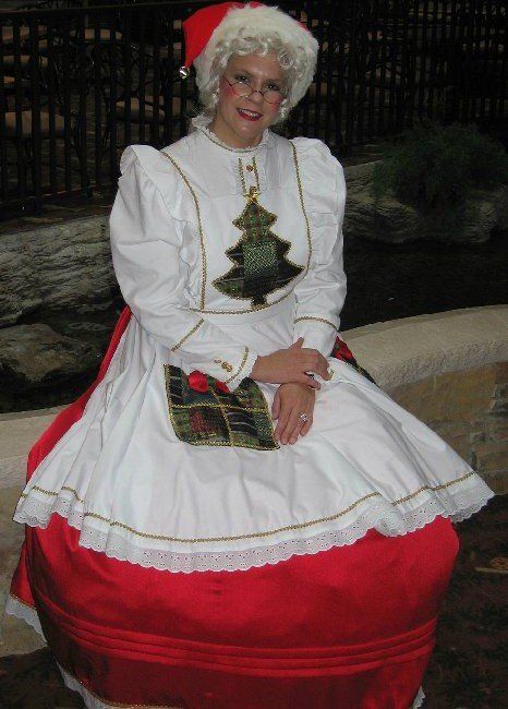 A woman in a santa costume is sitting on a bench