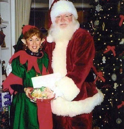 A man dressed as santa claus stands next to a woman dressed as an elf