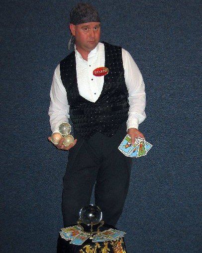 A man in a tuxedo is holding a crystal and playing cards
