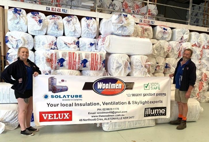A Man And A Woman Are Standing In Front Of A Large Pile Of Insulation — The Woolmen In Alstonville, NSW