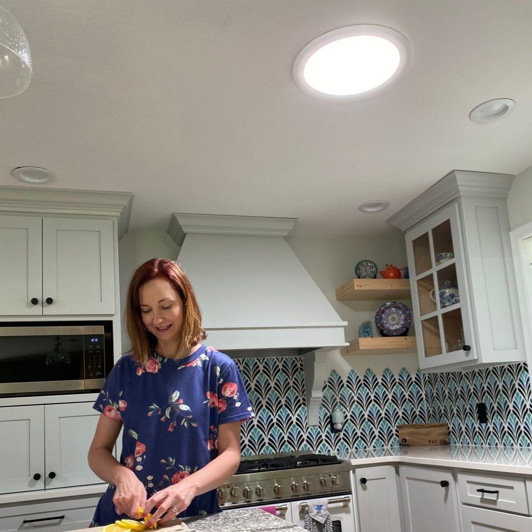 A Woman In A Blue Shirt Is Preparing Food In A Kitchen — The Woolmen In Alstonville, NSW