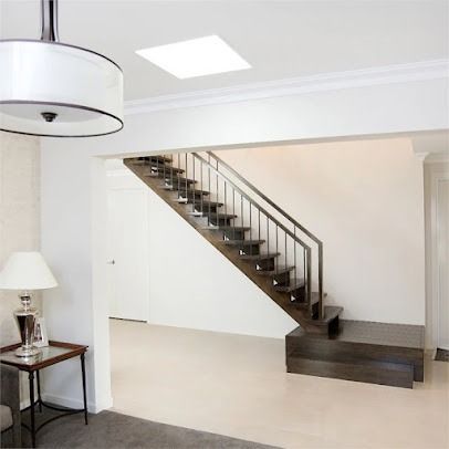 A Living Room With A Staircase And A Lamp — The Woolmen In Yamba, NSW