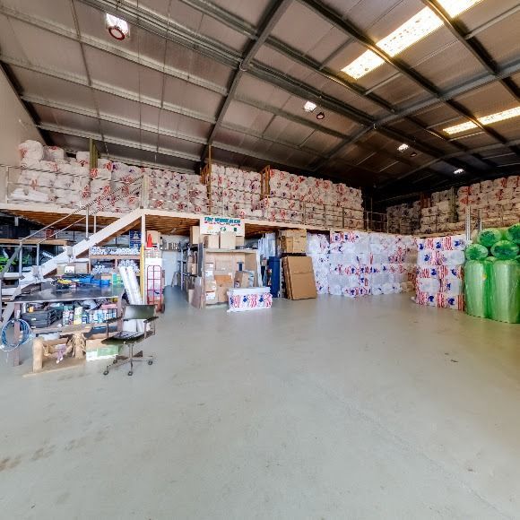 A Large Warehouse Filled With Lots Of Boxes And Green Bags — The Woolmen In Alstonville, NSW
