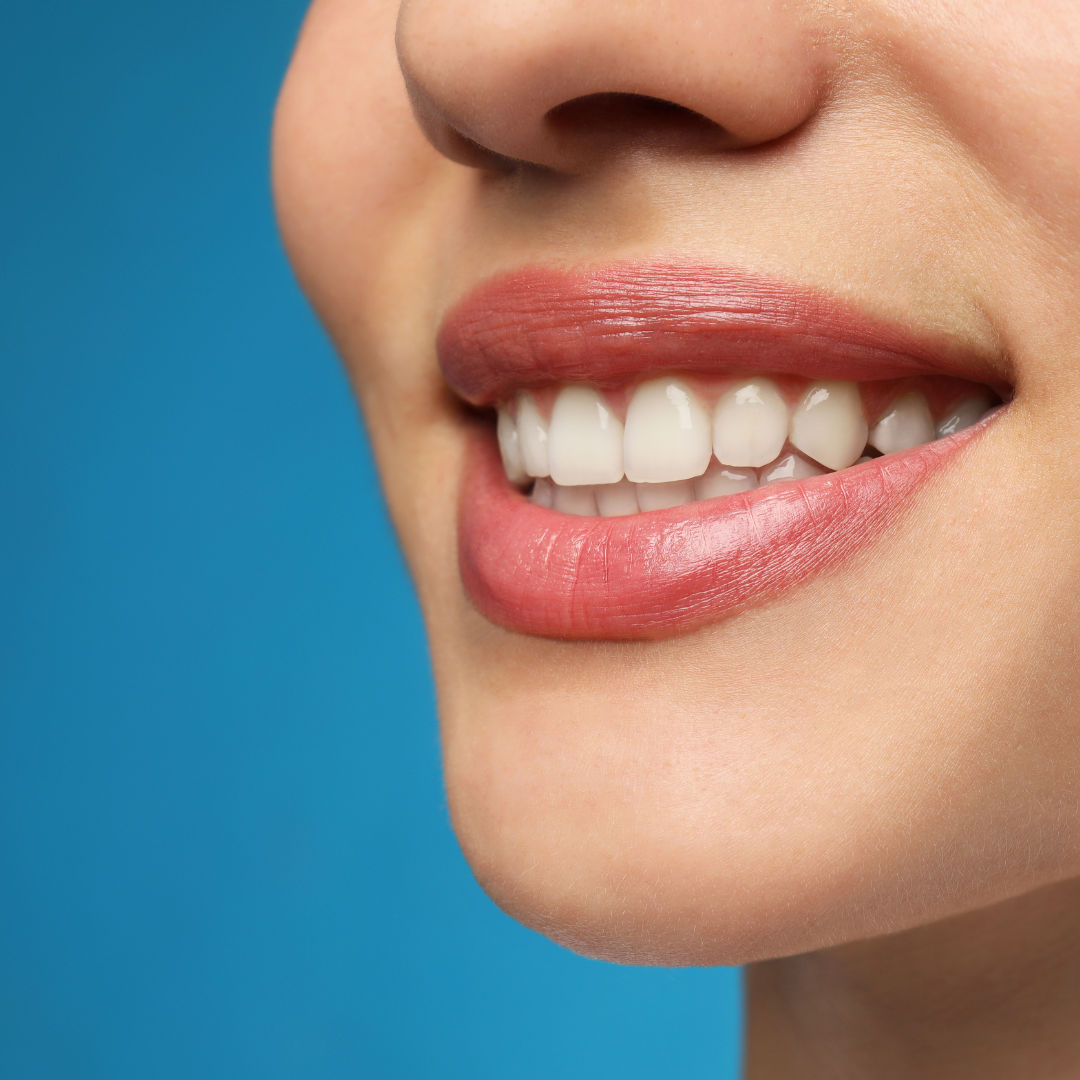 a close up of a woman 's smile with a blue background