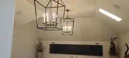 Two lanterns are hanging from the ceiling of a room.