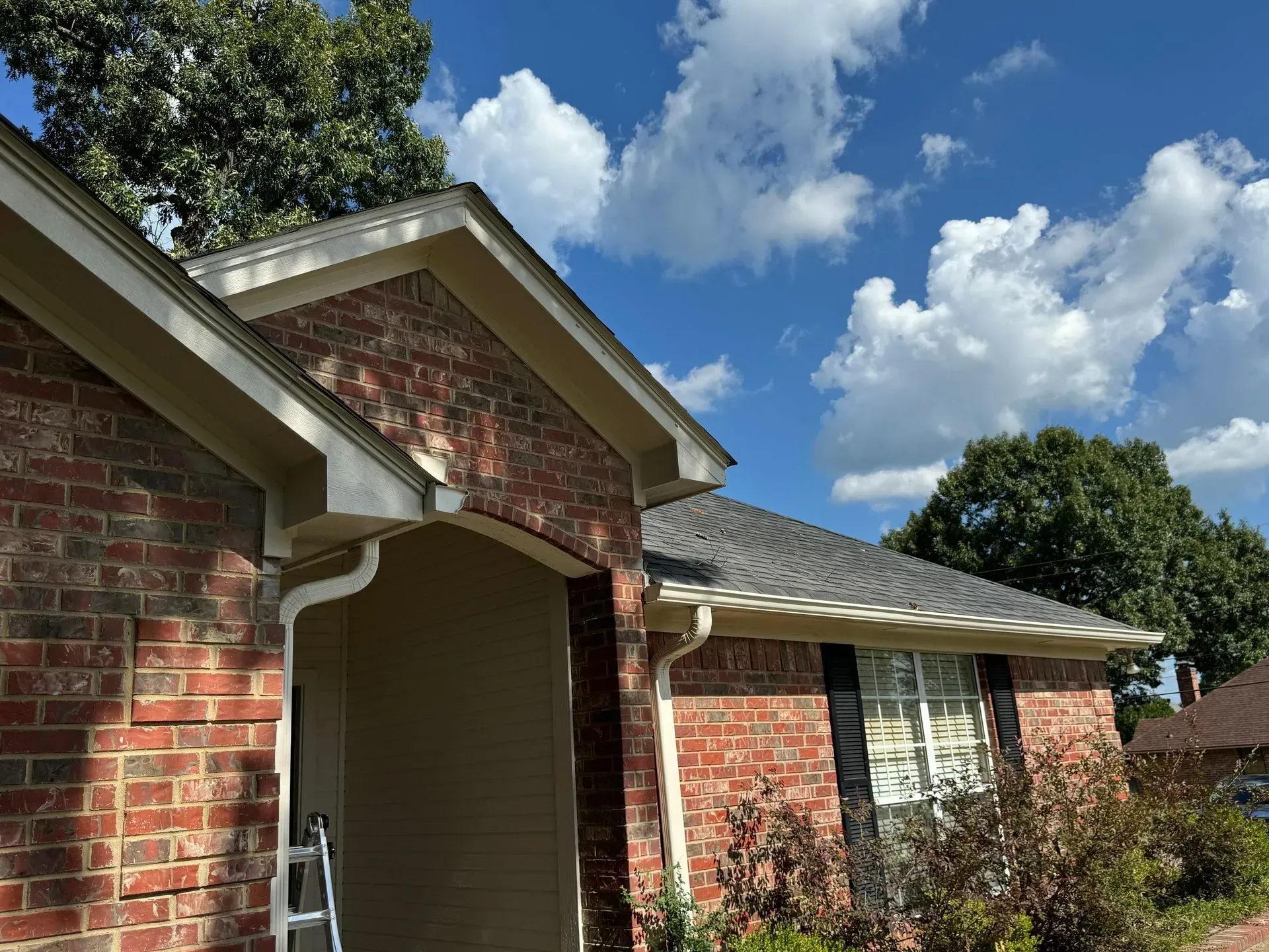 A brick house with a ladder in front of it.