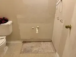 A bathroom with a toilet, sink, and door.