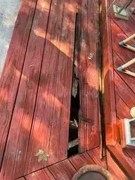 A red wooden deck with a hole in it.