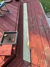 A piece of wood is sitting on top of a wooden deck.
