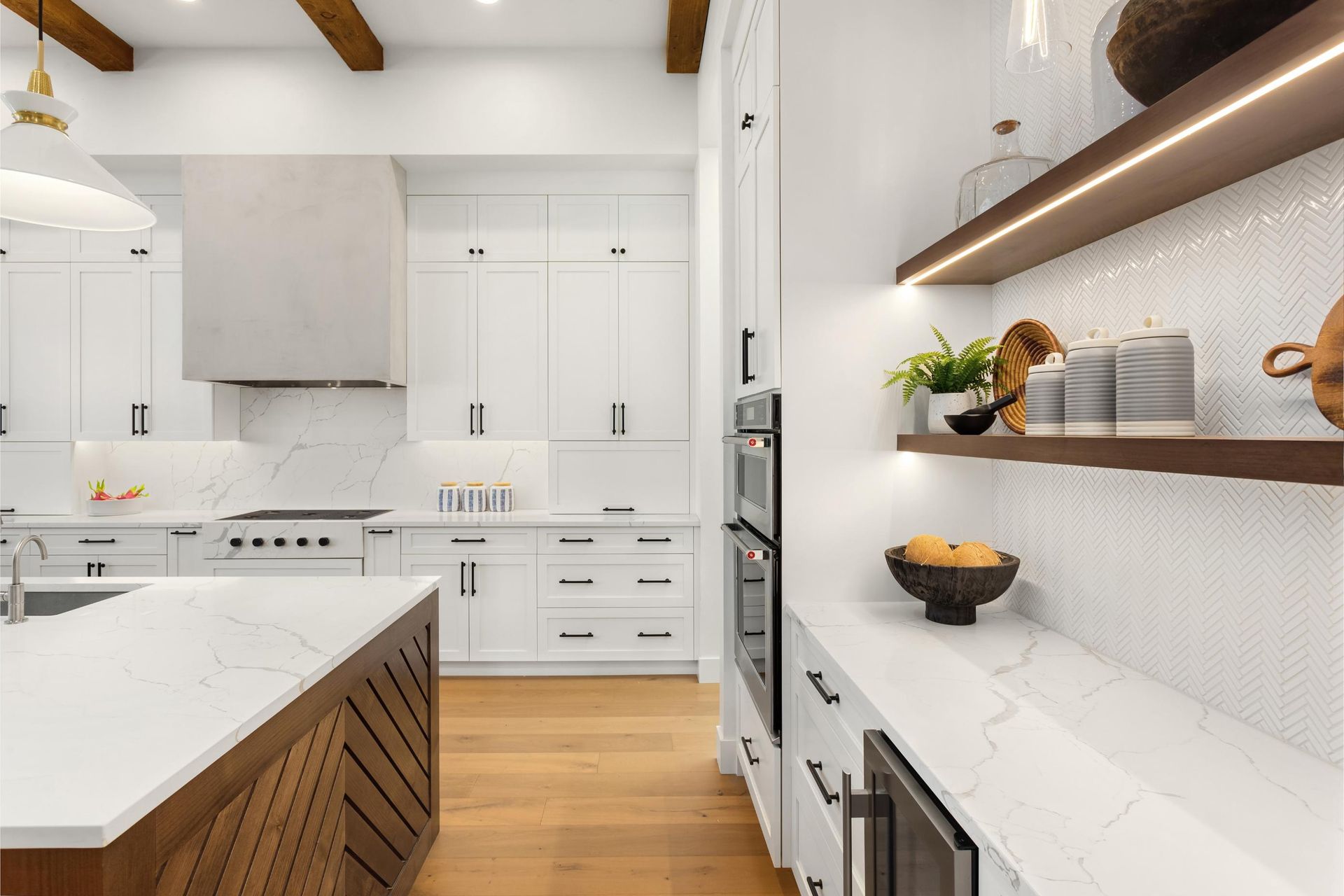 A kitchen with white cabinets, stainless steel appliances, and wooden floors.