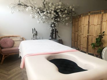 A pregnancy massage table in a room with a window.