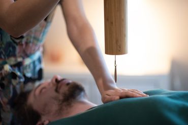 A man is receiving a energetic sound healing with Reiki and Koshi. 