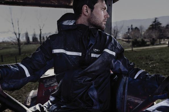 A man in a blue jacket is sitting in a car